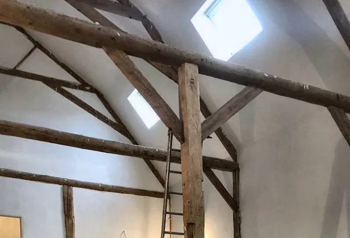 Zolder met houten balken en strak gestucte wanden, stucwerk in Rotterdam